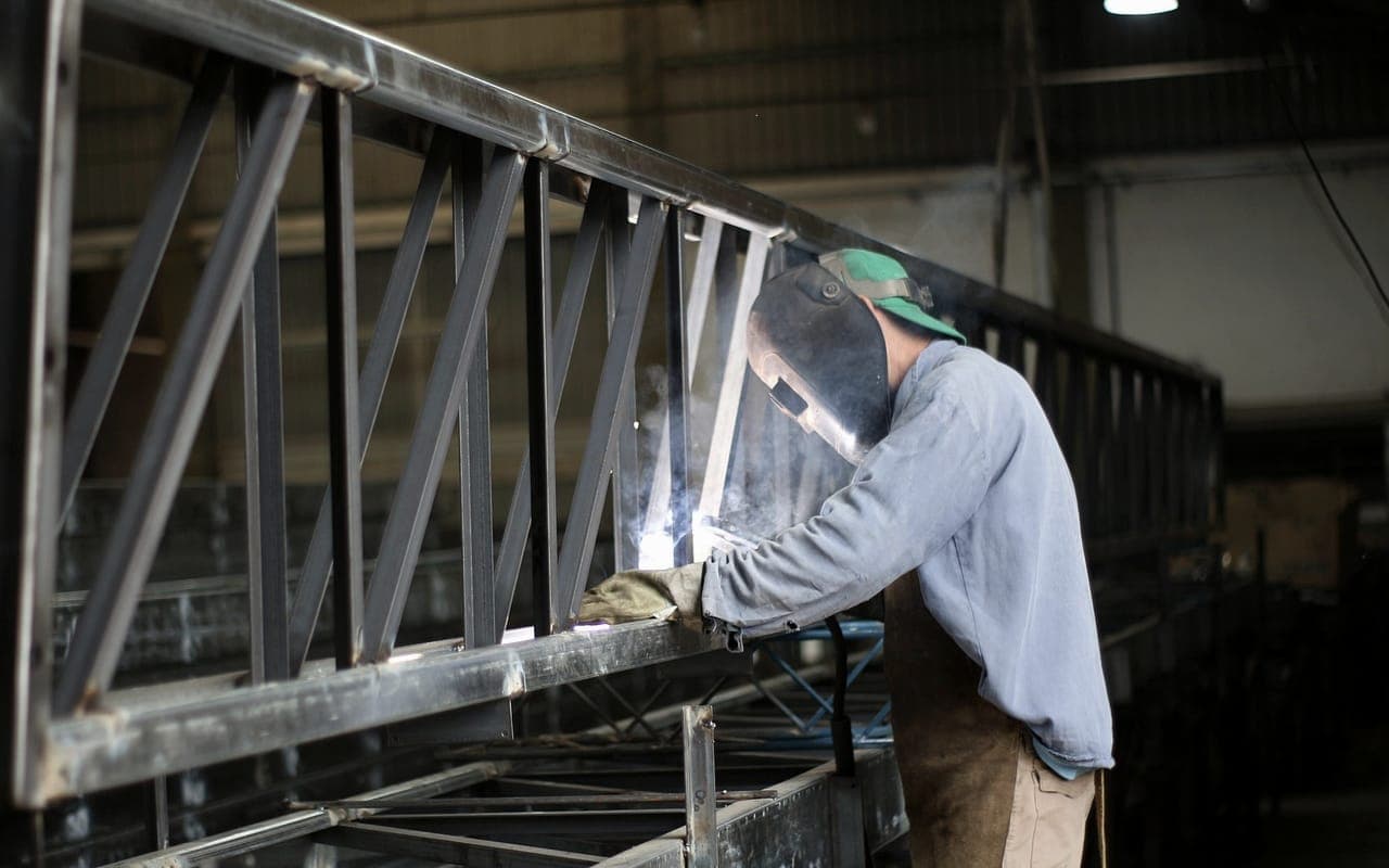 Soldador trabajando sobre una estructura metálica en taller